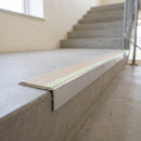 Aluminium stair nosing 56x32mm with photoluminescent strip and a beige anti-slip PVC insert, fitted to a concrete step