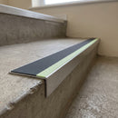 Aluminium stair nosing 56x32mm with photoluminescent strip and a midnight grey anti-slip PVC insert, fitted to a concrete step