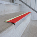 Aluminium stair nosing 56x32mm with photoluminescent strip and a red anti-slip PVC insert, fitted to a concrete step