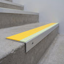 Aluminium stair nosing 56x32mm with photoluminescent strip and a yellow anti-slip PVC insert, fitted to a concrete step