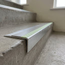 Ramped aluminium stair nosing 66x32mm with photoluminescent strip and a dolphin grey anti-slip PVC insert, fitted to a concrete step