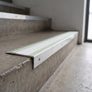 Ramped aluminium stair nosing 66x32mm with photoluminescent strip and a white anti-slip PVC insert, fitted to a concrete step
