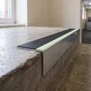 Aluminium stair nosing 56x55mm deep riser with photoluminescent strip and a black anti-slip PVC insert, fitted to a concrete step