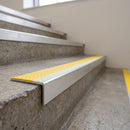 Aluminium stair nosing 56x55mm deep riser with photoluminescent strip and a yellow anti-slip PVC insert, fitted to a concrete step