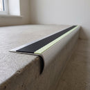 Bullnose aluminium stair nosing 69x40mm with photoluminescent strip and a black anti-slip PVC insert, fitted to a concrete step