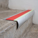 Bullnose aluminium stair nosing 69x40mm with photoluminescent strip and a red anti-slip PVC insert, fitted to a concrete step