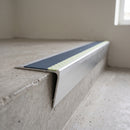 Raked-back aluminium stair nosing 67x55mm with photoluminescent strip and a cobalt blue anti-slip PVC insert, fitted to a concrete step