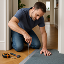 Homeowner fitting 49mm wide aluminium door threshold strip between hardwood and carpet in UK home - DIY screw fix installation