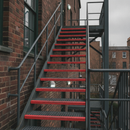 Red anti-slip tape on fire escape stair nosings — fire safety colour step edge marking