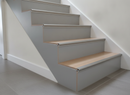 Silver aluminium push-in laminate stair nosing installed on 8mm grey laminate UK staircase - multiple steps visible