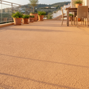 Sandstone TerraceShield anti-slip balcony paint applied to a balcony floor, a Mediterranean-style terrace with potted plants and warm sunlight
