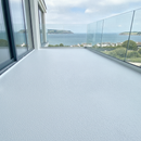 White TerraceShield anti-slip balcony paint applied to a balcony floor, a coastal apartment balcony overlooking the sea