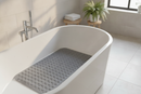 Grey non-slip suction bath mat laid inside a spa-style bathtub