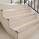Slimline aluminium stair nosings with beige inserts on cream tiled steps with black railing