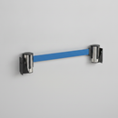 Two stainless steel wall-mounted retractable belt posts, one with a blue belt and one with a black belt, mounted on a wall on a plain studio background