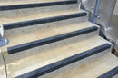 Black GRP anti-slip stair nosings fitted to concrete steps on an external access stair
