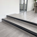 Black PVC bullnose stair nosing 50x25mm on grey LVT steps in an office reception