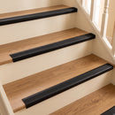 Black self-adhesive PVC bullnose stair nosing 50x25mm fitted to oak laminate stairs in a UK home