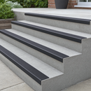 Black self-adhesive PVC stair nosing 50x25mm with a short riser lip on light concrete garden steps