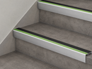 Black and green insert stair nosings fitted to two grey concrete-effect steps