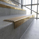 Solid brass stair nosing, 59.5mm tread with a 30mm square front, in Antique Brass finish with Fawn Castellated insert, fitted to a staircase