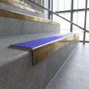 Solid brass stair nosing, 59.5mm tread with a 30mm square front, in Antique Brass finish with Mid Blue Castellated insert, fitted to a staircase