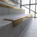 Solid brass stair nosing, 59.5mm tread with a 30mm square front, in Antique Brass finish with Nimbus Castellated insert, fitted to a staircase