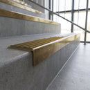 Solid brass stair nosing, 59.5mm tread with a 30mm square front, in Antique Brass finish with Olive Castellated insert, fitted to a staircase