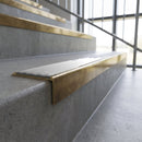 Solid brass stair nosing, 59.5mm tread with a 30mm square front, in Antique Brass finish with Polar Grey Smooth Textured insert, fitted to a staircase