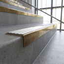 Solid brass stair nosing, 59.5mm tread with a 30mm square front, in Antique Brass finish with White Castellated insert, fitted to a staircase