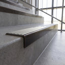 Solid brass stair nosing, 59.5mm tread with a 30mm square front, in Antique Bronze finish with Light Grey Castellated insert, fitted to a staircase