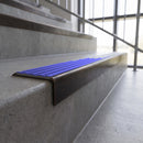 Solid brass stair nosing, 59.5mm tread with a 30mm square front, in Antique Bronze finish with Mid Blue Castellated insert, fitted to a staircase
