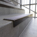 Solid brass stair nosing, 59.5mm tread with a 30mm square front, in Antique Bronze finish with Nimbus Castellated insert, fitted to a staircase