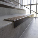 Solid brass stair nosing, 59.5mm tread with a 30mm square front, in Antique Bronze finish with Peat Castellated insert, fitted to a staircase