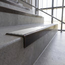 Solid brass stair nosing, 59.5mm tread with a 30mm square front, in Antique Bronze finish with Polar Grey Smooth Textured insert, fitted to a staircase