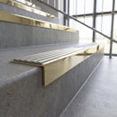 Solid brass stair nosing, 59.5mm tread with a 30mm square front, in Polished Brass finish with Light Grey Castellated insert, fitted to a staircase