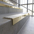 Solid brass stair nosing, 59.5mm tread with a 30mm square front, in Polished Brass finish with Polar Grey Castellated insert, fitted to a staircase
