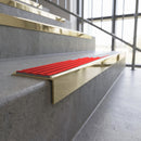 Solid brass stair nosing, 59.5mm tread with a 30mm square front, in Polished Brass finish with Poppy Castellated insert, fitted to a staircase