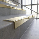 Solid brass stair nosing, 59.5mm tread with a 30mm square front, in Polished Brass finish with Porth Stone Smooth Textured insert, fitted to a staircase
