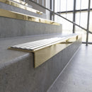 Solid brass stair nosing, 59.5mm tread with a 30mm square front, in Polished Brass finish with White Castellated insert, fitted to a staircase
