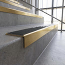 Solid brass stair nosing, 59.5mm tread with a 30mm square front, in Satin Brass finish with Black Olympic Grip insert, fitted to a staircase