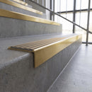 Solid brass stair nosing, 59.5mm tread with a 30mm square front, in Satin Brass finish with Fawn Castellated insert, fitted to a staircase
