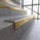 Solid brass stair nosing, 59.5mm tread with a 30mm square front, in Satin Brass finish with Flint Castellated insert, fitted to a staircase