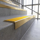 Solid brass stair nosing, 59.5mm tread with a 30mm square front, in Satin Brass finish with Gold Castellated insert, fitted to a staircase