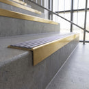 Solid brass stair nosing, 59.5mm tread with a 30mm square front, in Satin Brass finish with Nimbus Castellated insert, fitted to a staircase