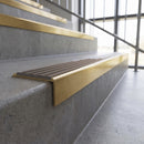 Solid brass stair nosing, 59.5mm tread with a 30mm square front, in Satin Brass finish with Peat Castellated insert, fitted to a staircase