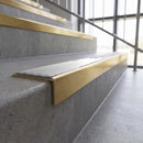 Solid brass stair nosing, 59.5mm tread with a 30mm square front, in Satin Brass finish with Polar Grey Smooth Textured insert, fitted to a staircase