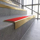 Solid brass stair nosing, 59.5mm tread with a 30mm square front, in Satin Brass finish with Poppy Castellated insert, fitted to a staircase