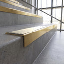 Solid brass stair nosing, 59.5mm tread with a 30mm square front, in Satin Brass finish with Porth Stone Smooth Textured insert, fitted to a staircase