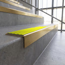 Solid brass stair nosing, 59.5mm tread with a 30mm square front, in Satin Brass finish with Yellow Castellated insert, fitted to a staircase